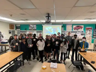 Group of students posing inside a classroom with SolarBuddy product